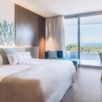 Habitaci&oacute;n moderna de hotel con vista al mar y decoraci&oacute;n elegante
