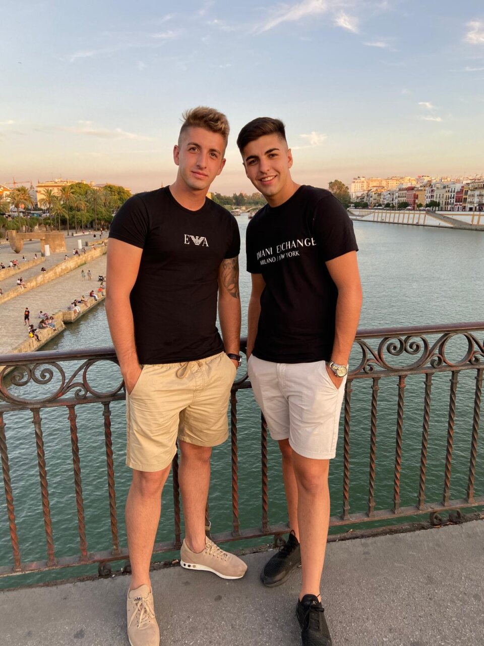 Dos j&oacute;venes posando en un puente con vista al mar en Mallorca
