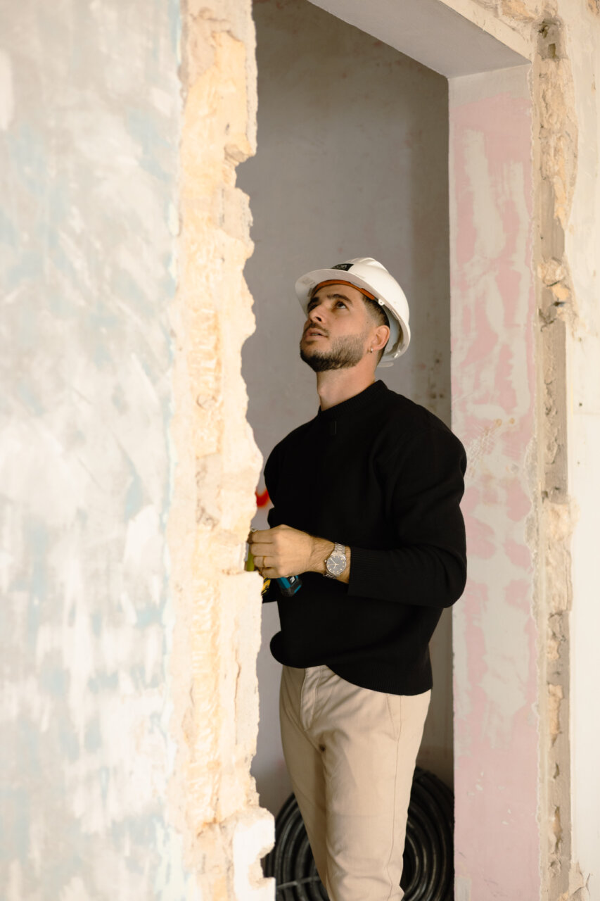 Joven ingeniero observando el proceso de construcci&oacute;n de una vivienda
