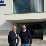Dos hombres estrechando manos frente a Juaneda Hospitales en Menorca