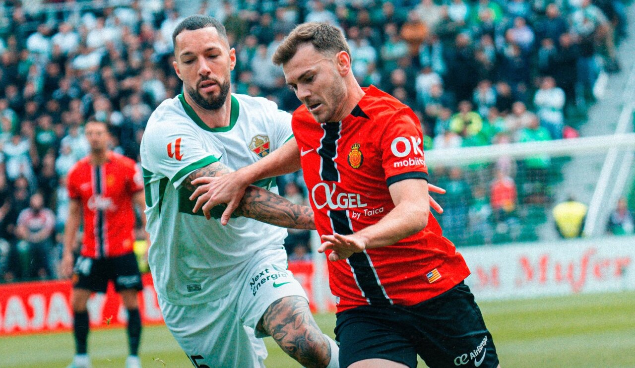 Jugadores del RCD Mallorca y Elche compiten por el bal&oacute;n en un partido