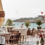 Camarera sirviendo un cóctel en un restaurante junto al mar