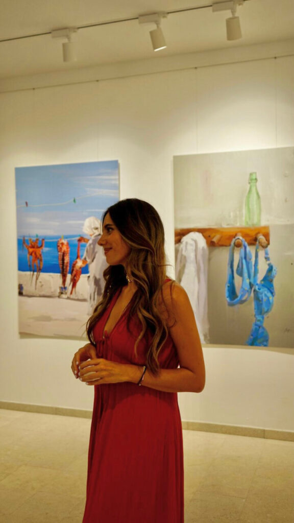 Magda Trobat en una galer&iacute;a de arte con pinturas de fondo