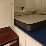 Interior de un mini piso con cama y muebles compactos