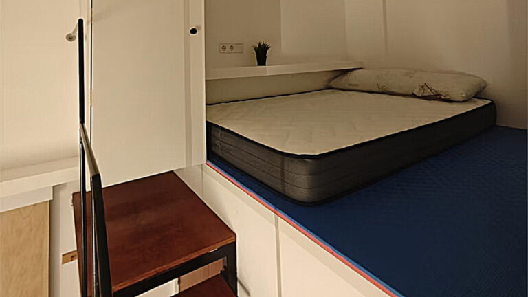 Interior de un mini piso con cama y muebles compactos