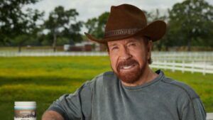 Chuck Norris posando con un sombrero en un campo verde