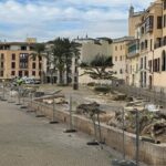 Vista de la plaza con &aacute;rboles talados y cercas de obra