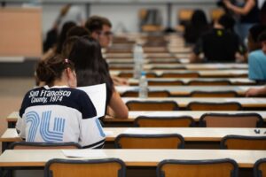 Estudiantes en un examen de la PAU en un aula con mesas y sillas