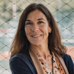 Retrato de Pilar Carbonell sonriendo frente a una red