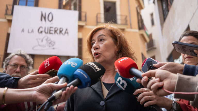 Francina Armengol hablando ante los medios con un cartel de No a la guerra detr&aacute;s.