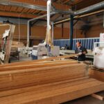 Hombre trabajando en una f&aacute;brica de madera con maquinaria y tablones