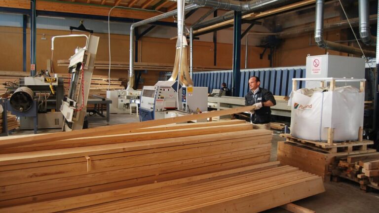 Hombre trabajando en una f&aacute;brica de madera con maquinaria y tablones