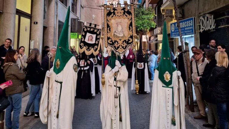 Cofrades en la procesi&oacute;n de la Semana Santa en Palma con estandartes