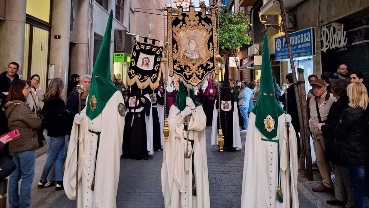 Cofrades en la procesi&oacute;n de la Semana Santa en Palma con estandartes