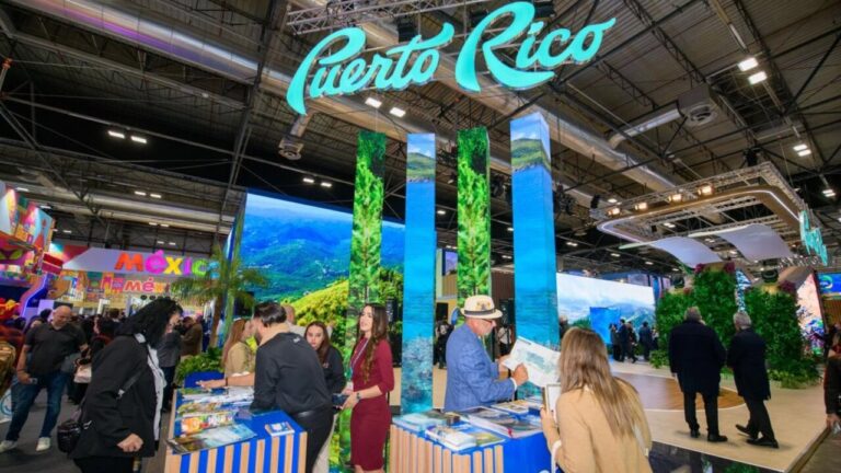 Stand de Puerto Rico en la feria Fitur con visitantes interactuando.