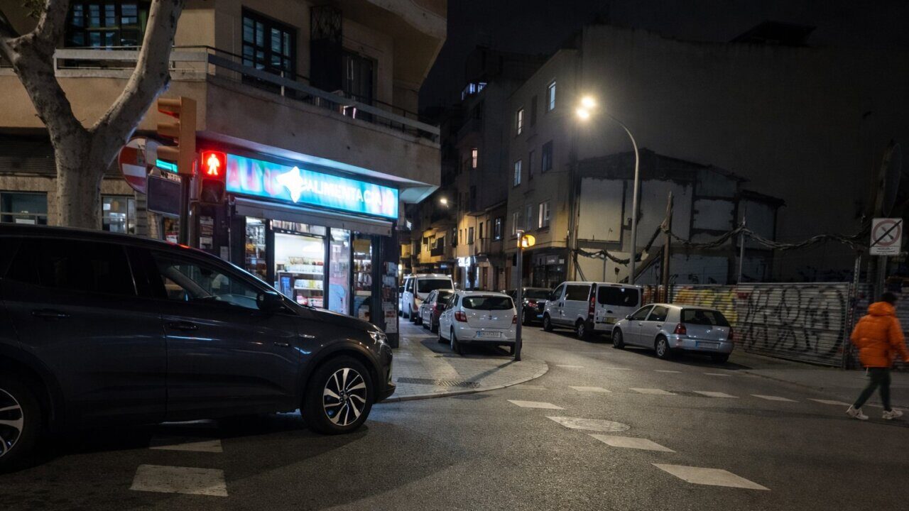 Vista nocturna de un supermercado en Pere Garau con coches estacionados.