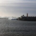 Vista del mar agitado en Baleares con olas y un faro