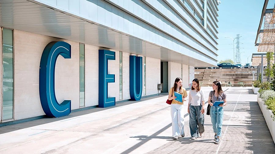 Tres estudiantes caminando frente al edificio del CEU en Mallorca