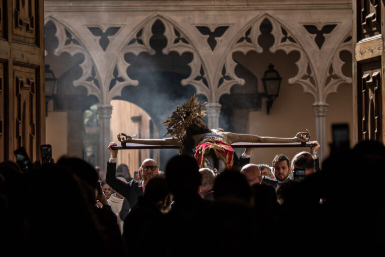 Fieles sosteniendo la imagen del Cristo de la Sang en un templo