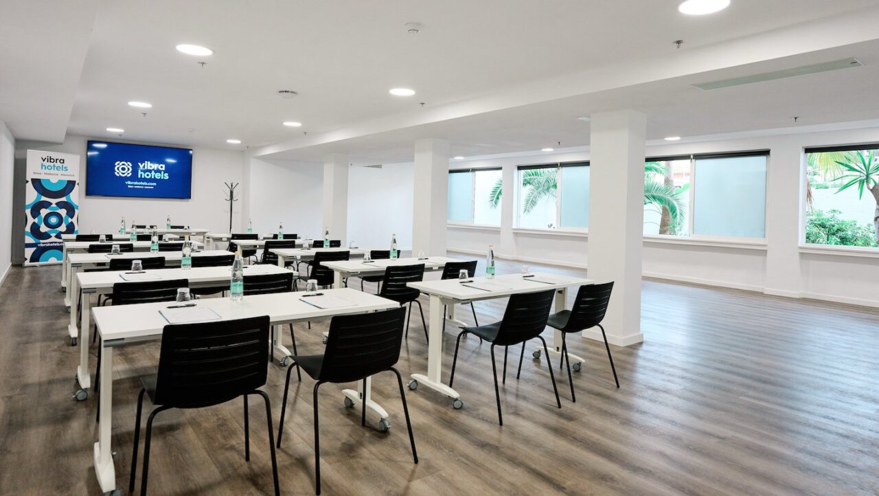 Sala de eventos en Vibra Hotels con mesas y sillas dispuestas