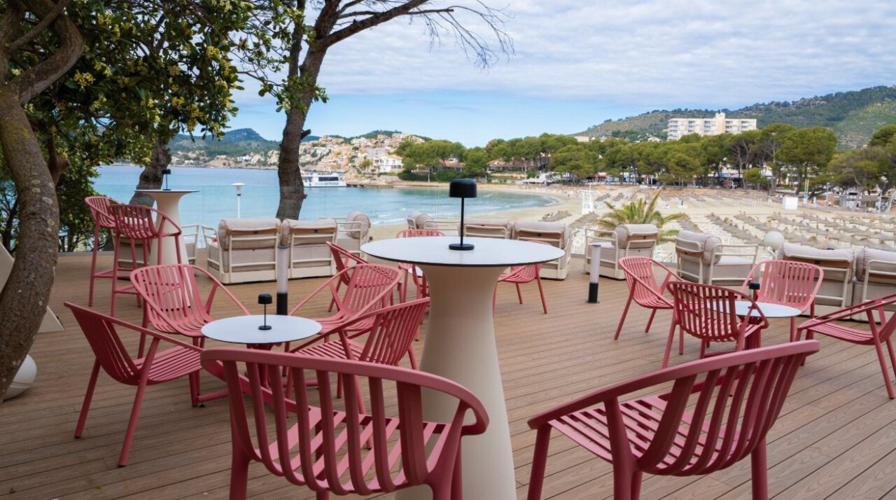 Terraza con sillas rojas y vista al mar en Mallorca