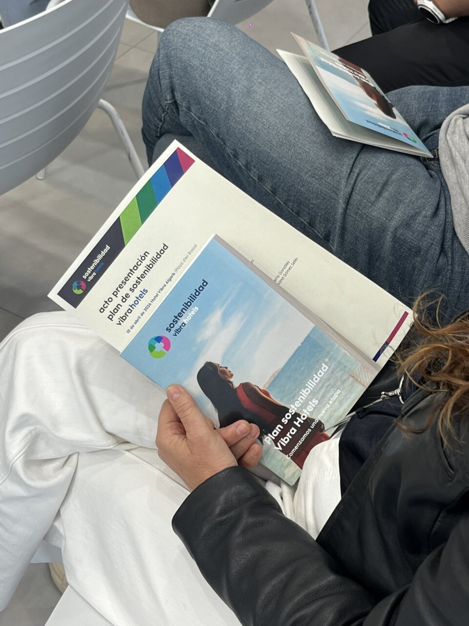 Persona sosteniendo un folleto sobre sostenibilidad de Vibra Hotels