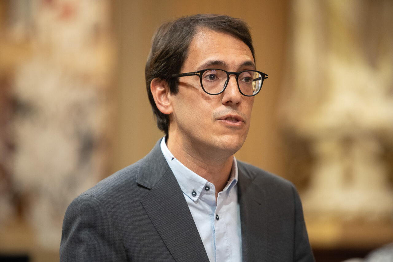 Hombre hablando en el Parlament de Mallorca con fondo decorativo