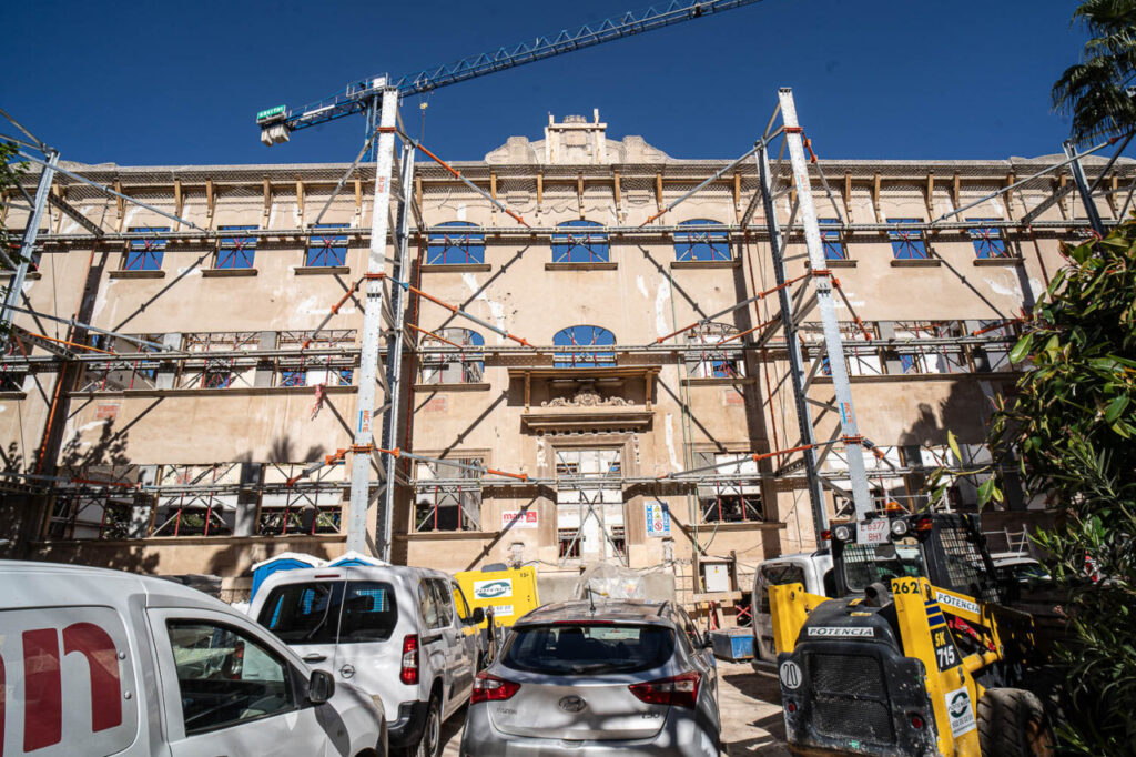 Fachada del edificio Cecili Metel en rehabilitaci&oacute;n con andamios y maquinaria