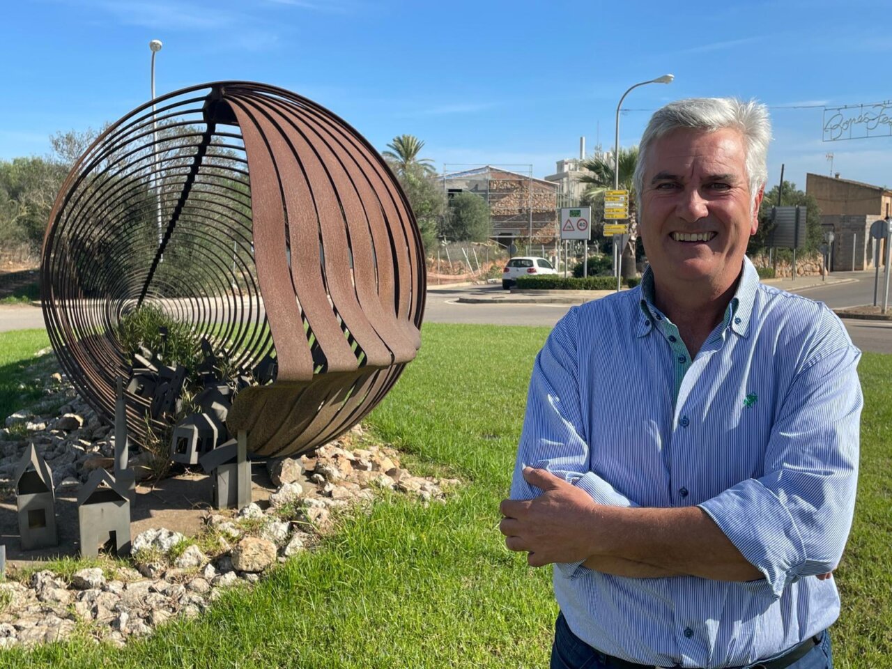 Hombre sonriente junto a una escultura en Ses Salines