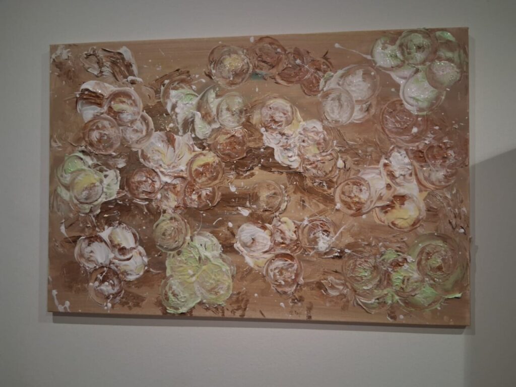 Pintura abstracta con tonos marrones y verdes en un lienzo.