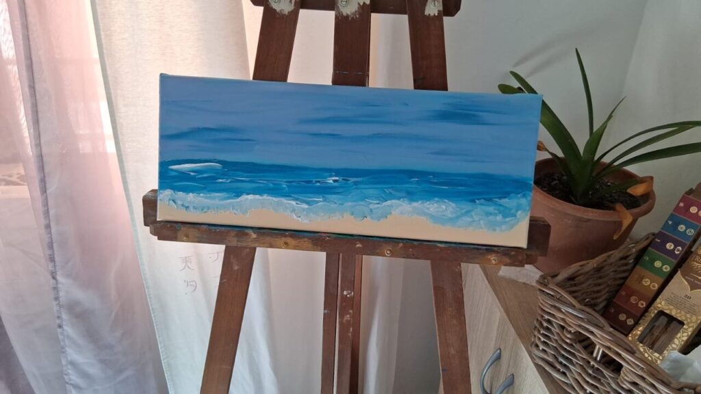 Pintura de un paisaje marino en un caballete