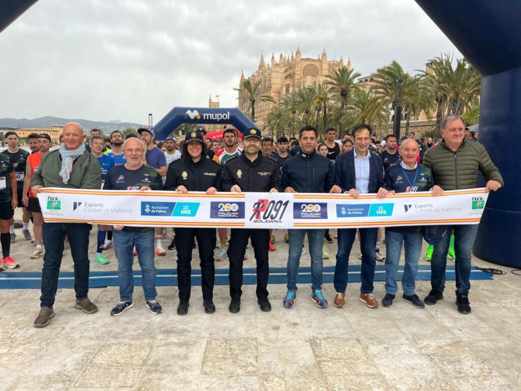 Participantes de la carrera solidaria Ruta 091 en Palma con banner