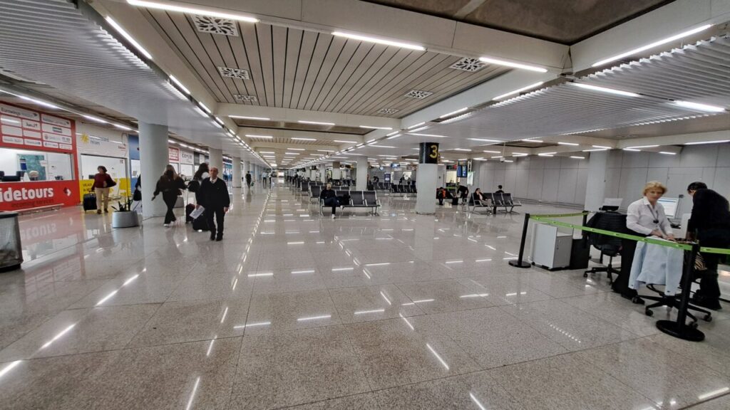 Interior del aeropuerto con pasajeros y mostradores de atenci&oacute;n