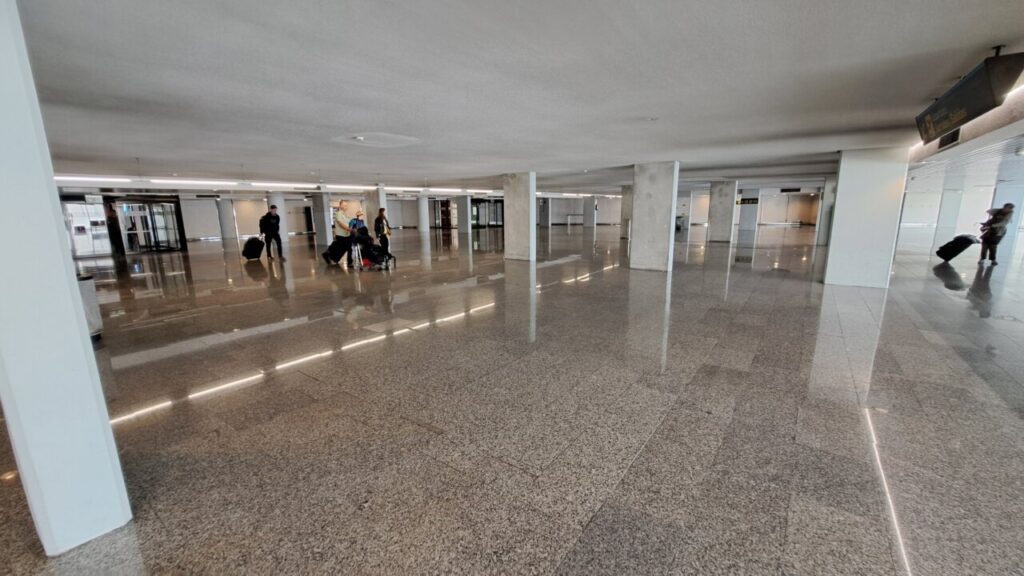 Interior del aeropuerto con pasajeros y equipaje en movimiento