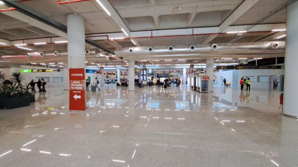 Interior del aeropuerto de Mallorca con se&ntilde;alizaci&oacute;n y viajeros