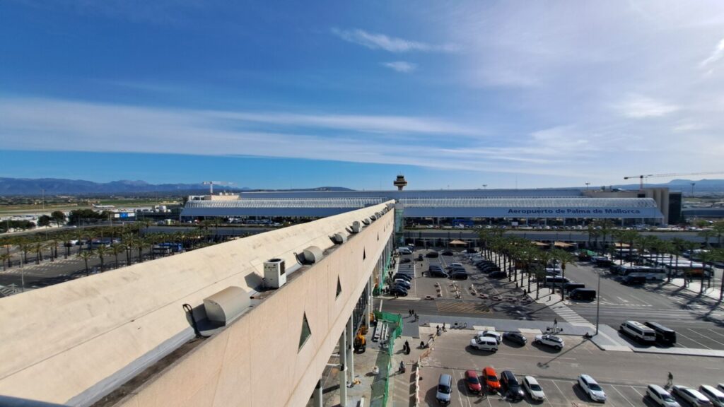 Vista panor&aacute;mica del Aeropuerto de Palma de Mallorca con aparcamiento y monta&ntilde;as al fondo