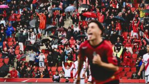 Aficionados del RCD Mallorca celebrando un gol en el estadio bajo la lluvia