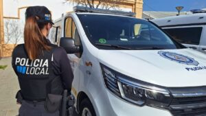 Agente de la Polic&iacute;a Local de Palma de espaldas junto a un veh&iacute;culo policial.