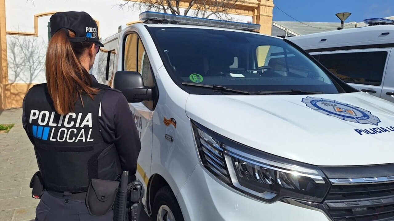 Agente de la Polic&iacute;a Local de Palma de espaldas junto a un veh&iacute;culo policial.