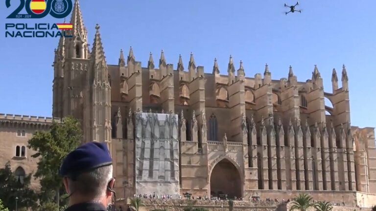 Agente de la Policía Nacional observando un dron sobrevolando La Seu en Palma