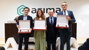 Cuatro personas sosteniendo placas conmemorativas en la Asamblea General de ASIMA