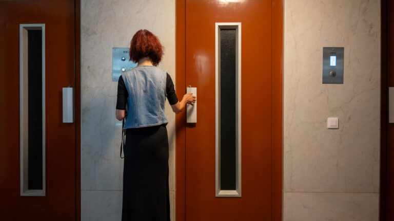 Mujer esperando en un ascensor en un edificio moderno