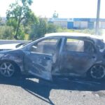Bomberos apagando un coche incendiado en la autopista de Inca