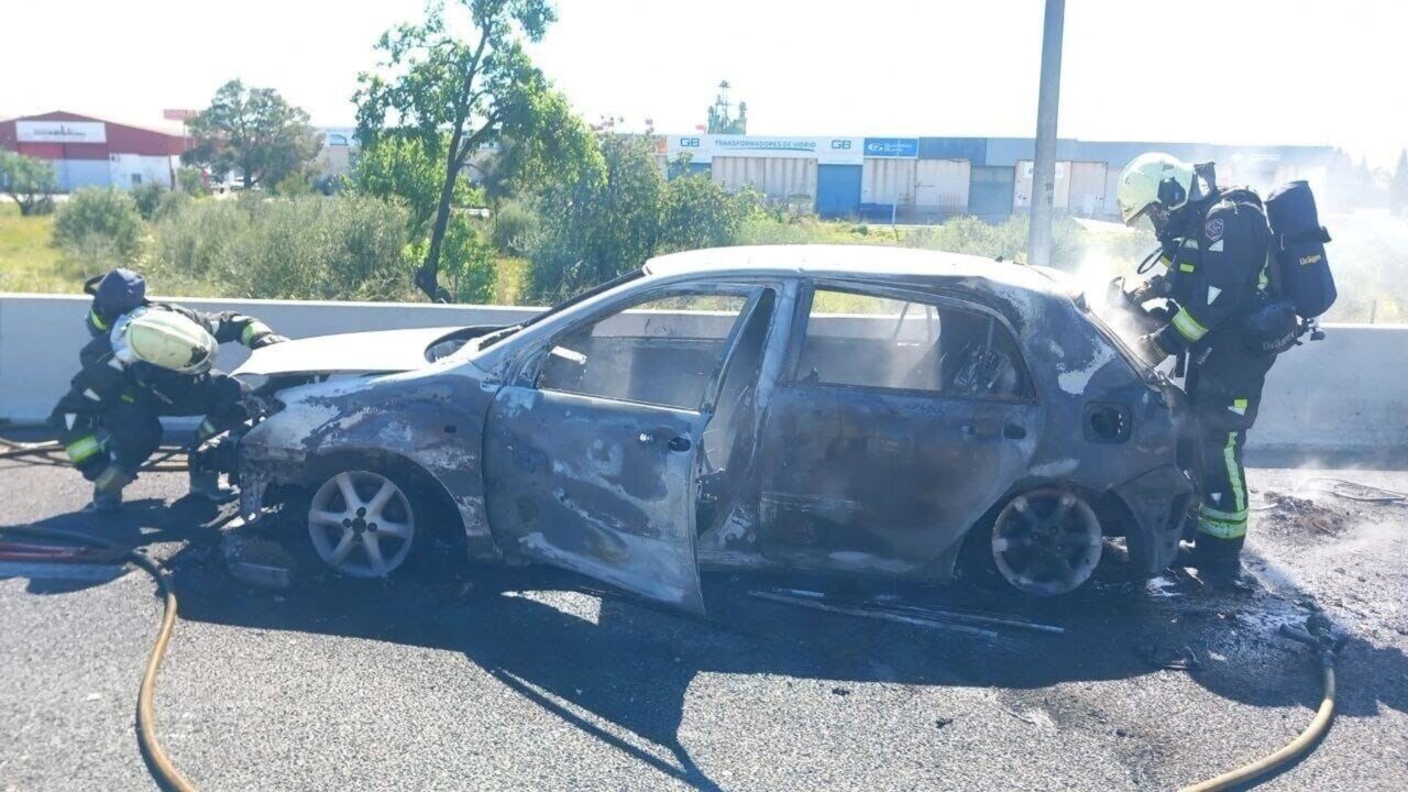 Bomberos apagando un coche incendiado en la autopista de Inca