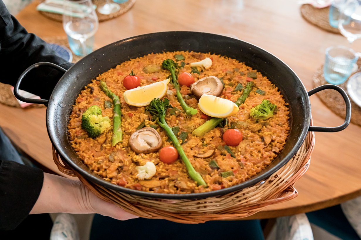 Plato de paella con verduras y mariscos en un restaurante
