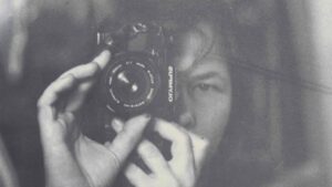 Persona sosteniendo una c&aacute;mara Olympus mientras se toma una selfie