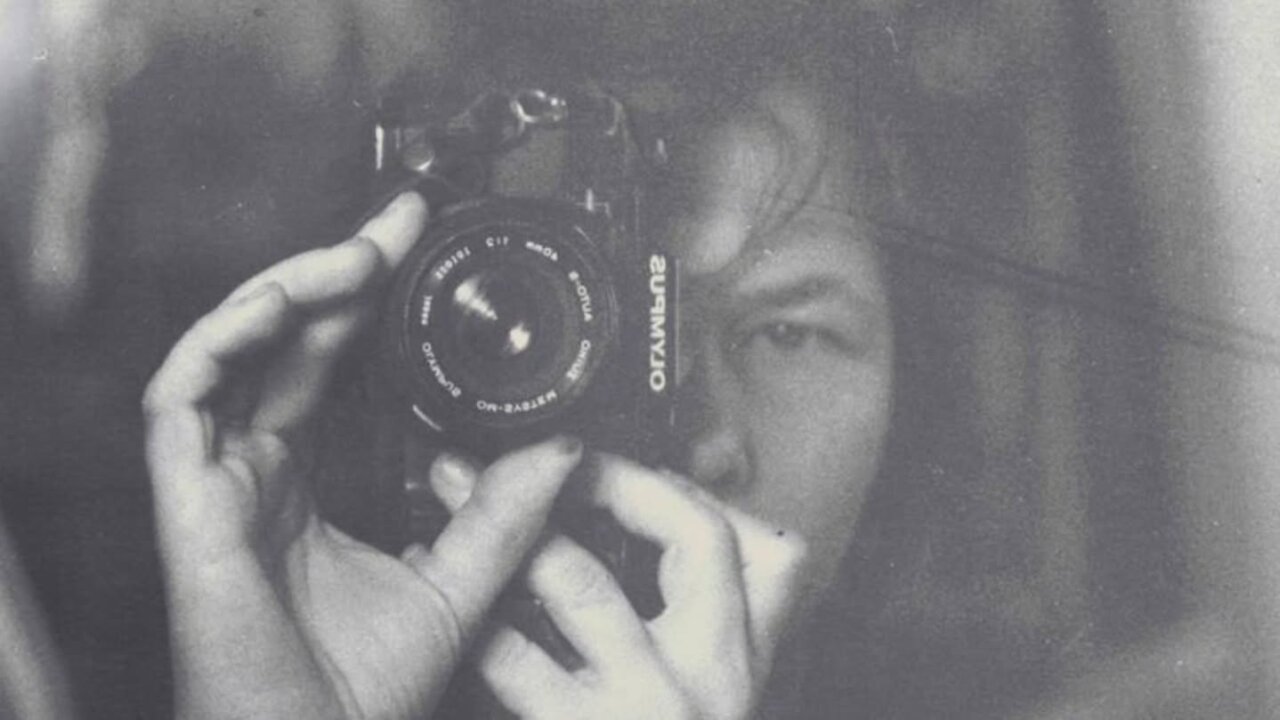 Persona sosteniendo una c&aacute;mara Olympus mientras se toma una selfie