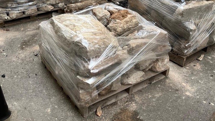 Piedras apiladas en palets para la renovación de aceras en Inca