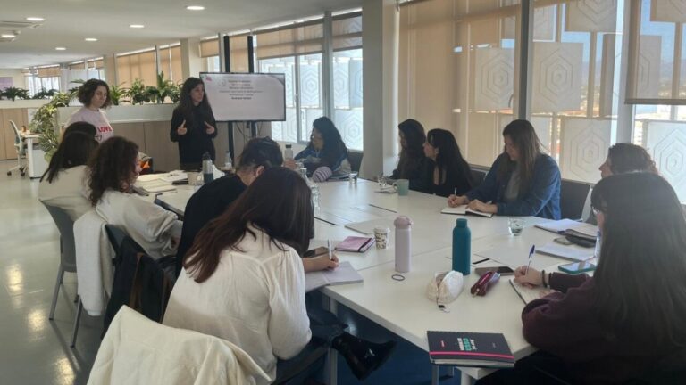 Reunión sobre sensibilización y prevención del suicidio con participantes tomando notas.