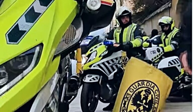 Motocicletas de la Guardia Civil con bandera amarilla en carretera